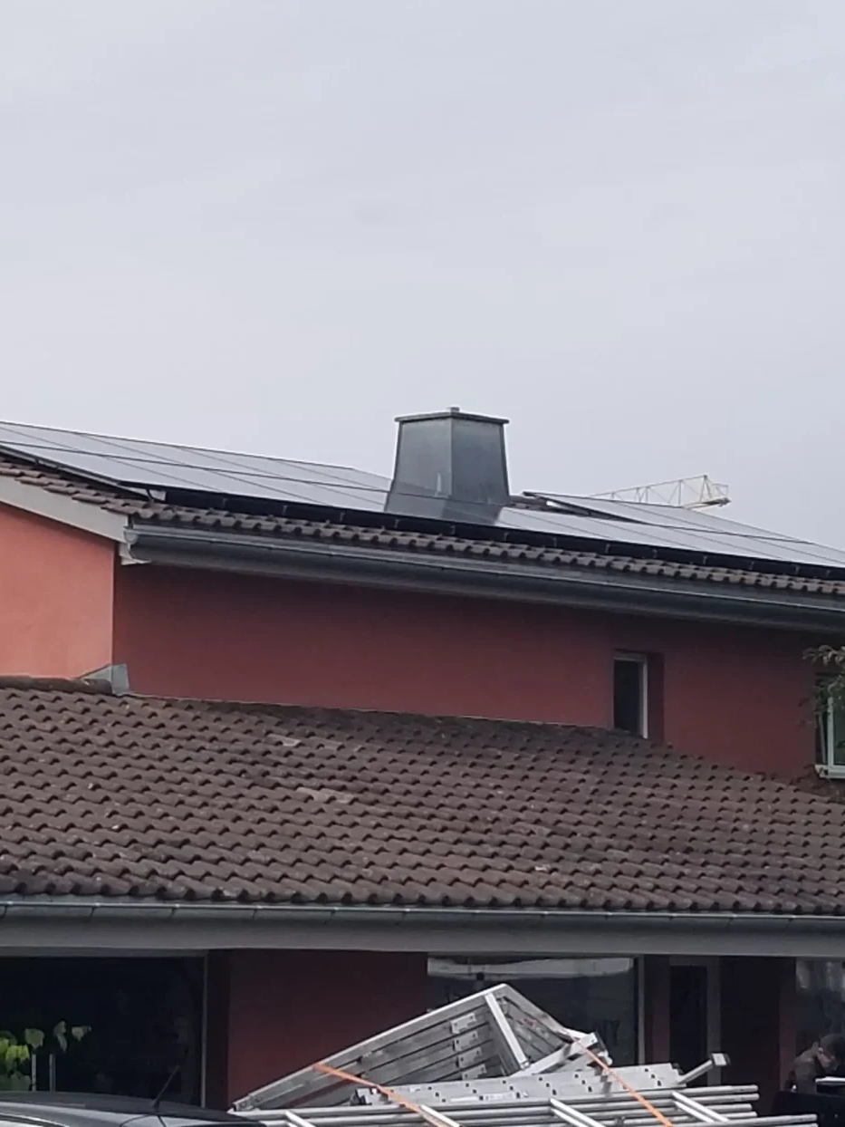 Dach eines roten Wohnhauses bei der PV-Montage