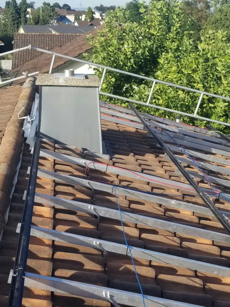 Montageschienen auf einem Ziegeldach mit Baugerüst